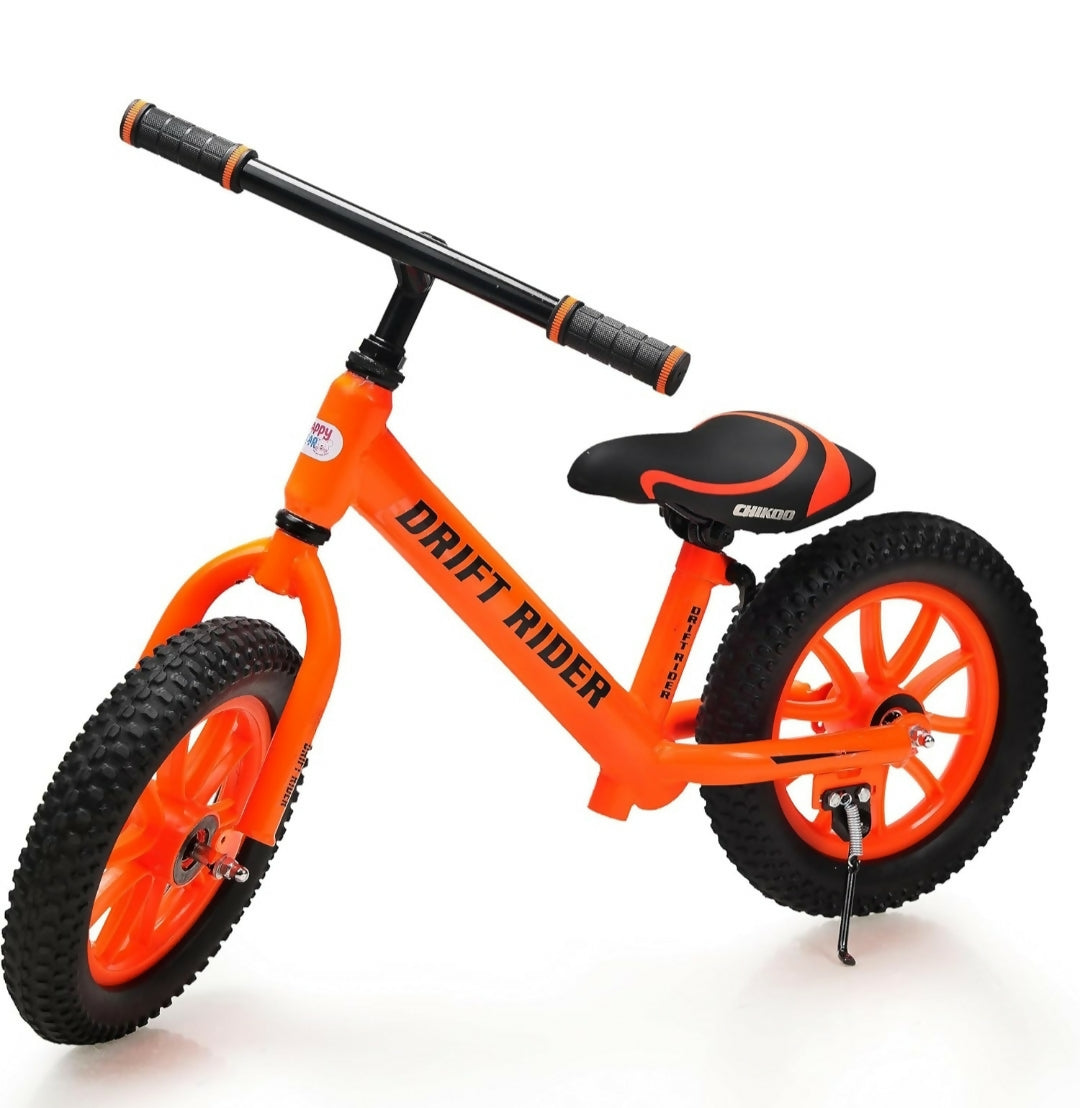 Orange balance bike with black seat and wheels on a white background