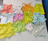 Collection of colorful baby clothes on a white surface