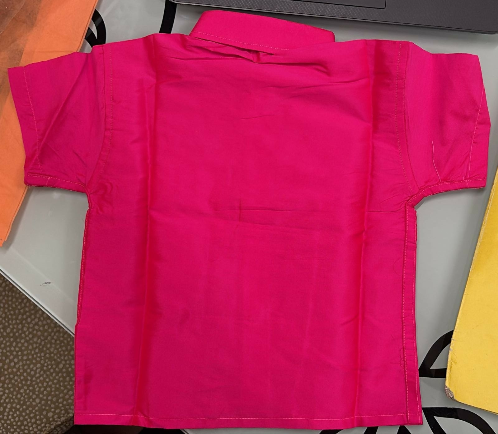 Bright pink shorts on a table with a colorful background