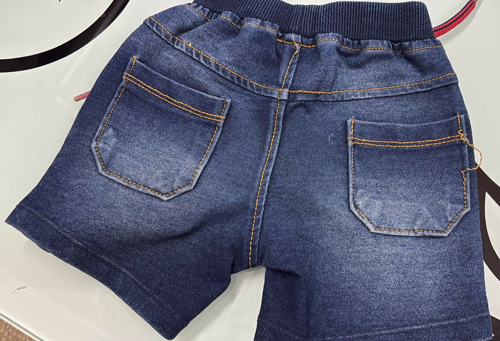 Blue denim jacket with two front pockets on a white background