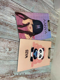 Two notebooks with different designs on a wooden surface