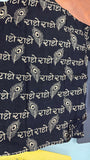 Dark fabric with white patterns and text on a light blue background