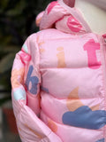 Close-up of a pink children's jacket with colorful letters and shapes.