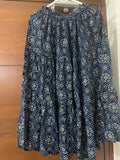 Blue patterned dress on a hanger against a wooden door background