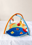 Mee Mee Baby Activity Play Gym Tummy Time Mat with hanging toys, soft cushioned mat, foldable design, and carry bag to encourage tummy time, sensory development, and motor skills.