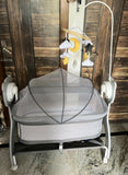 MEE MEE Swing Cradle for Baby featuring a mosquito net, comfortable mattress pad, gentle swinging design and wheels with locking function for convenient movement and supervised resting at home.