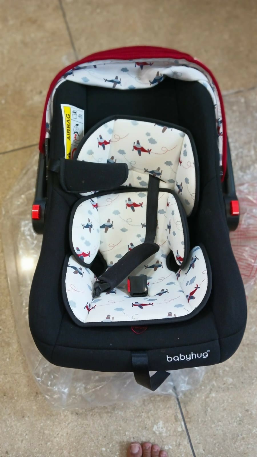 Babyhug Amber Car Seat Cum Carry Cot with padded seating, secure safety harness, ergonomic carry handle, protective canopy, and versatile design for comfortable travel with newborns and infants.