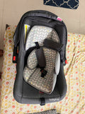 Babyhug Car Seat Cum Carry Cot with rocking base for newborns, rear-facing infant car seat featuring a 5-point safety harness, ergonomic carry handle, padded seat, and removable canopy for safe travel and comfortable carrying.