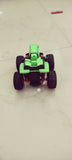Toy car with green body and black wheels on a tiled floor