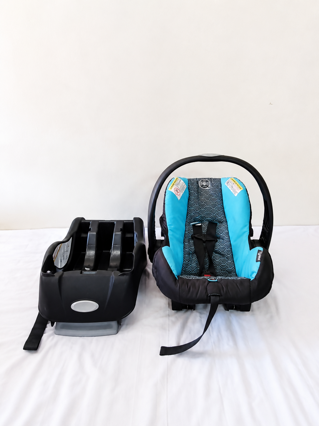 Evenflo Embrace infant car seat with base, rear-facing design, cushioned newborn support, secure safety harness, and portable baby carrier functionality for safe travel.