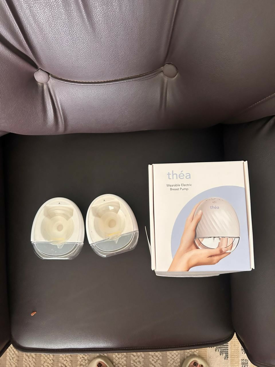 Théa wearable electric breast pump with hands-free design, compact milk collection cups, adjustable suction, and portable pumping support for breastfeeding mothers.