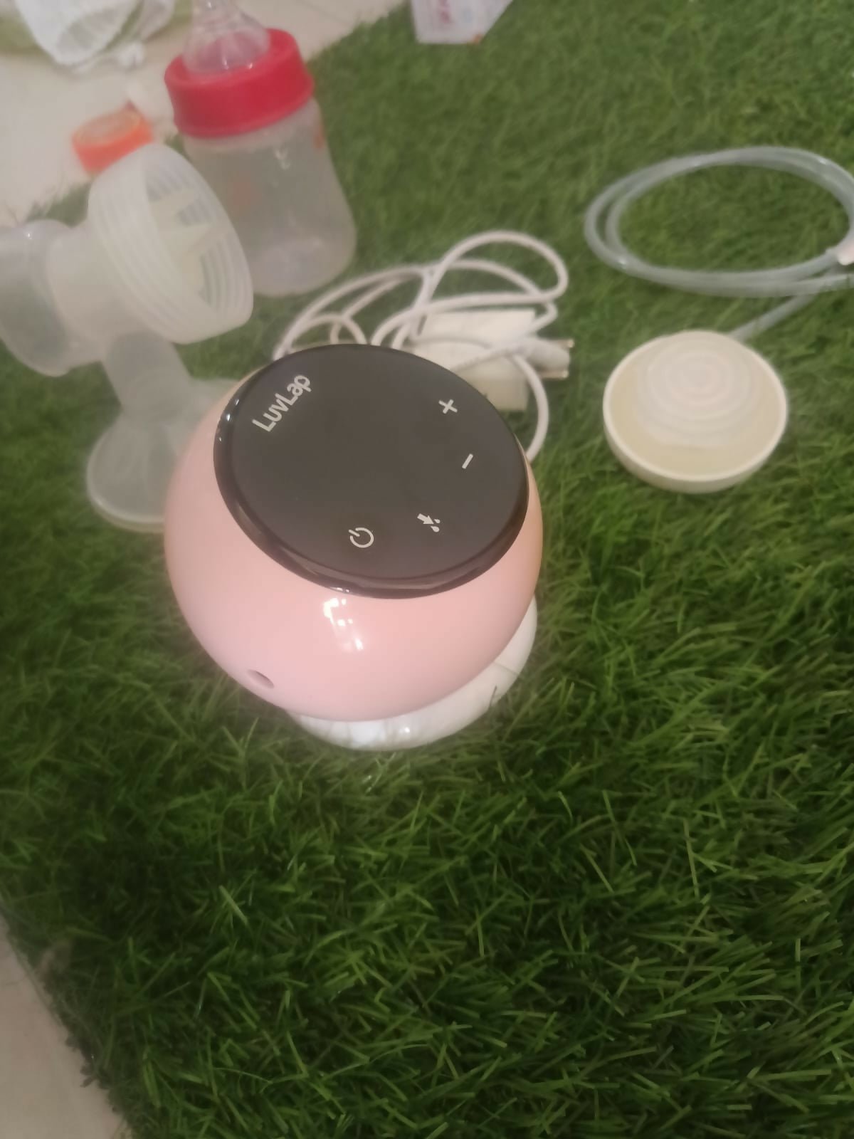 LUVLAP Adore electric breast pump with LUVLAP feeding bottle, adjustable suction settings, compact design, and convenient milk collection support for breastfeeding mothers.