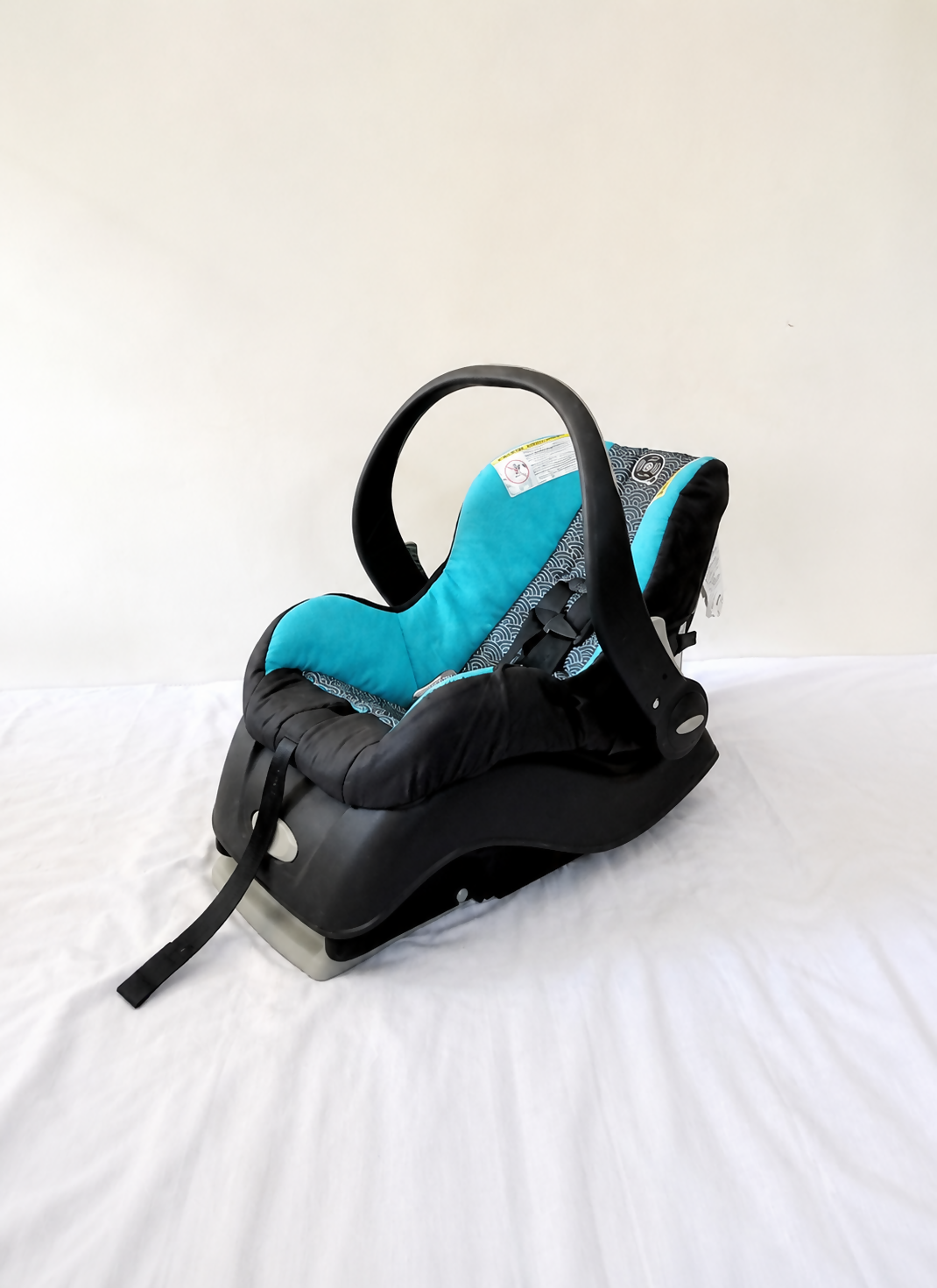 Evenflo Embrace infant car seat with base, rear-facing design, cushioned newborn support, secure safety harness, and portable baby carrier functionality for safe travel.