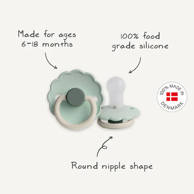 Two pacifiers with text indicating age range, material, and shape on a white background.