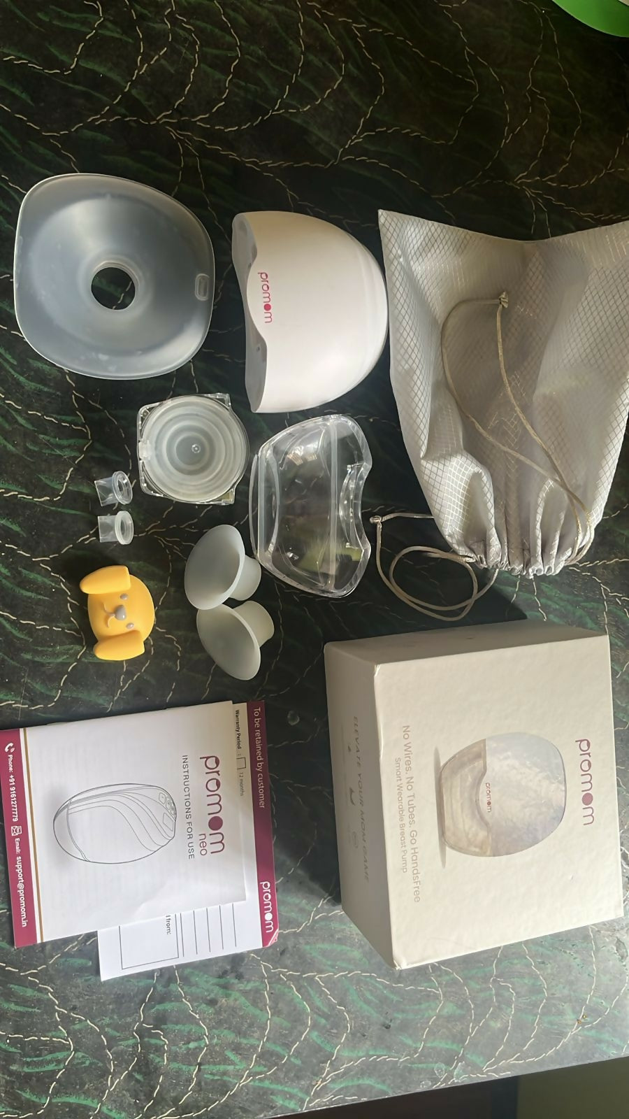 Collection of breast pump parts and accessories on a dark surface