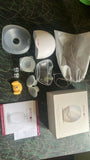 Collection of breast pump parts and accessories on a dark surface