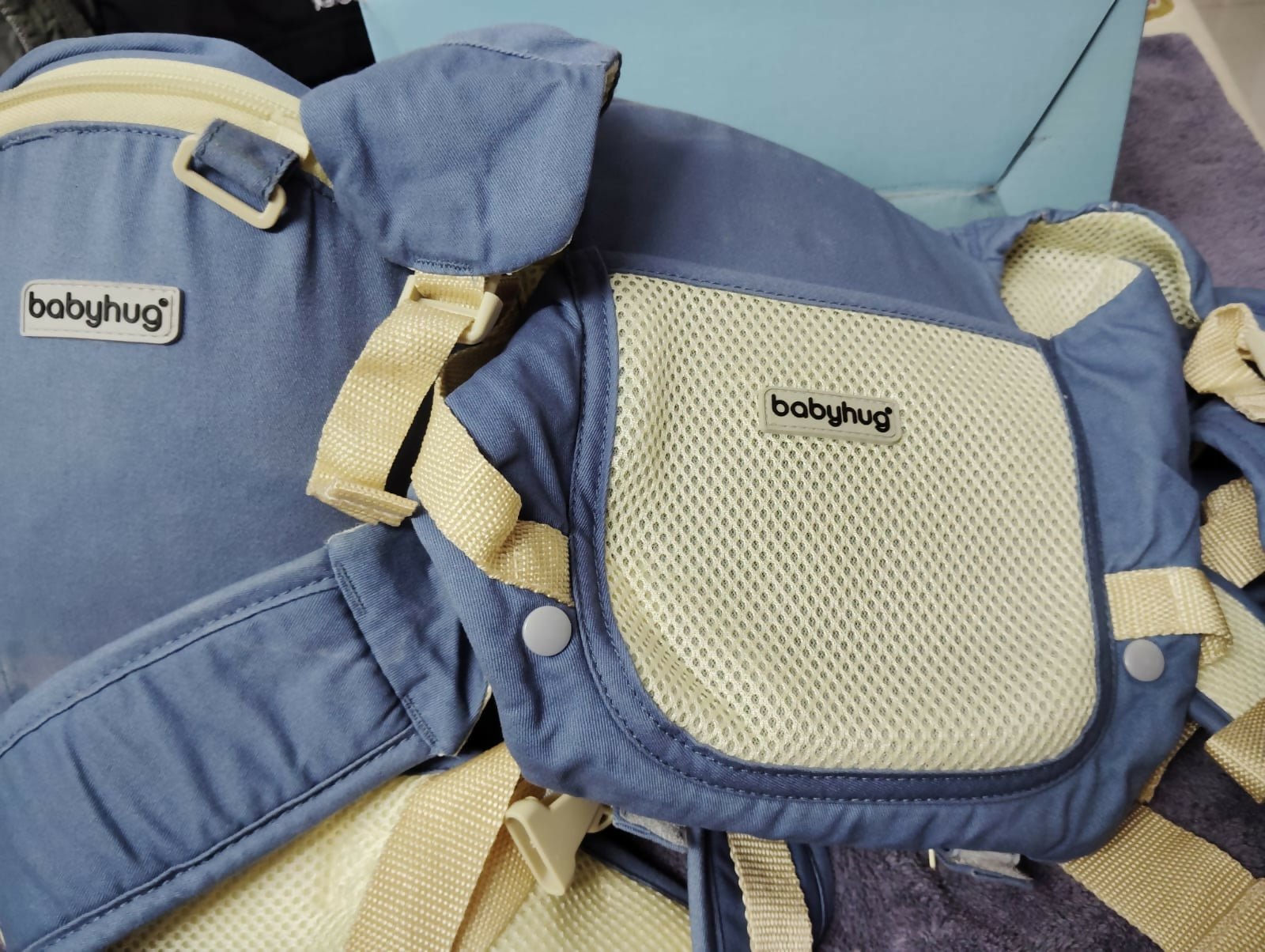 BABYHUG Adore 5-in-1 hip seat baby carrier with ergonomic design, detachable hip seat, multiple carrying positions, padded shoulder straps, adjustable waist belt, and secure buckles for comfortable babywearing.