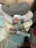 Stack of travel pillows with a visible brand tag on a patterned surface