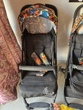Black stroller with colorful canopy and footmuff