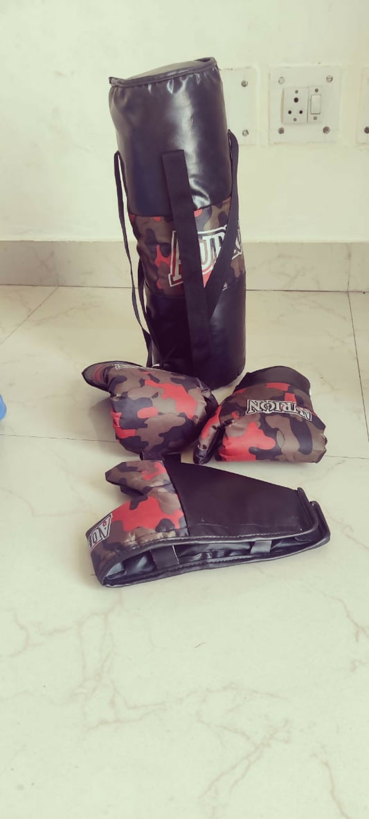 Camouflage-patterned boxing gloves and punching bag on a tiled floor.