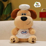 Plush dog toy wearing a chef's hat and 'Cook' apron on a beige surface with a blurred background.