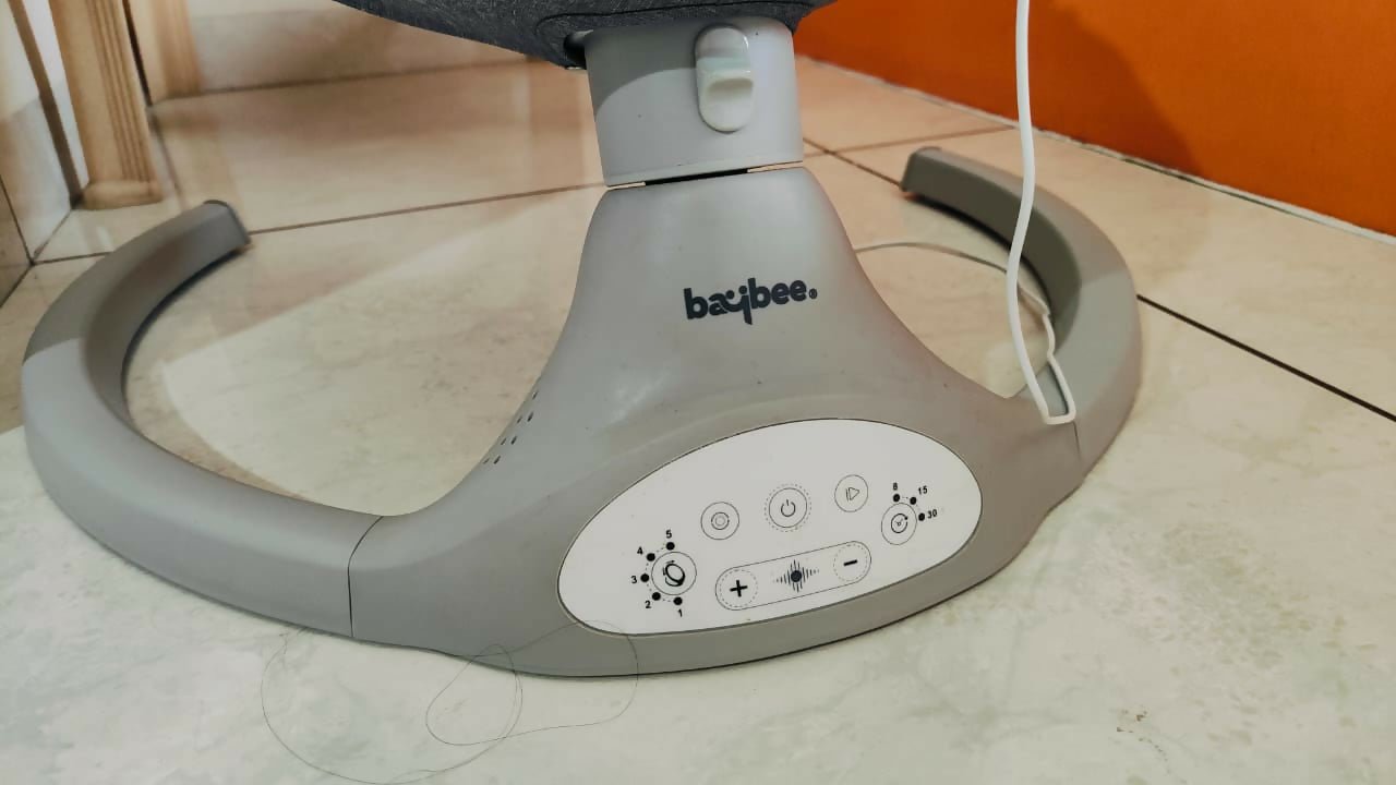 BAYBEE electric baby swing with gentle rocking motion, cushioned seat, secure safety harness, soothing comfort, and relaxing support for babies during rest and play.