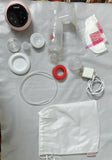 Collection of breast pump parts and accessories on a white surface