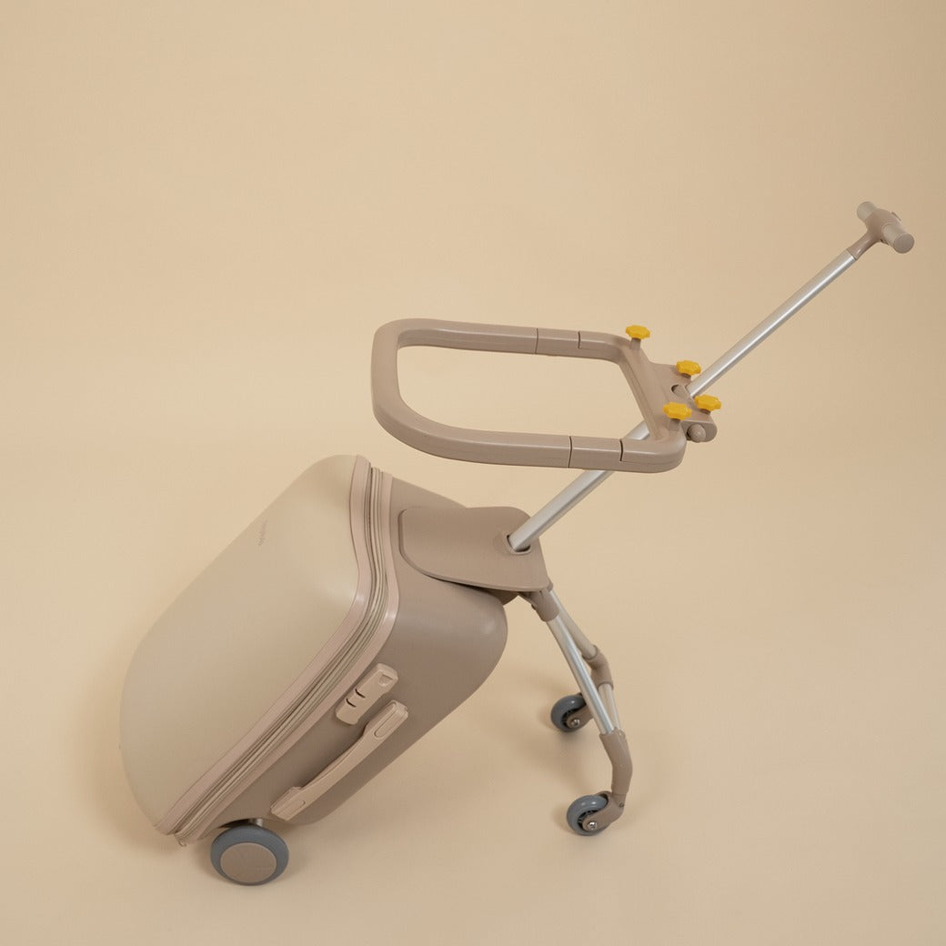 Beige suitcase with a rolling handle on a beige background