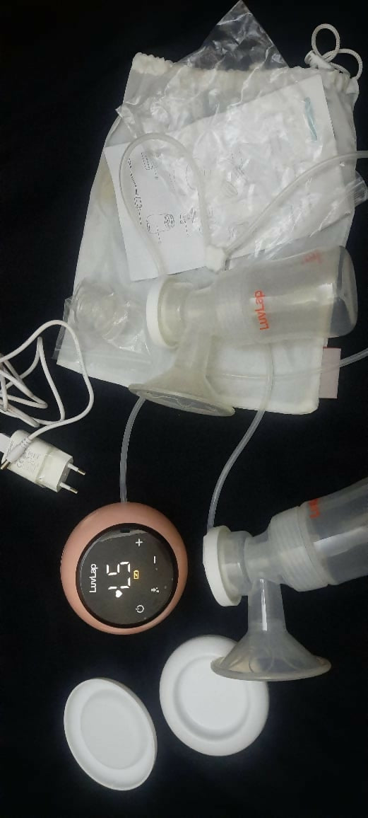 Breast pump with accessories on a dark surface