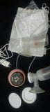 Breast pump with accessories on a dark surface
