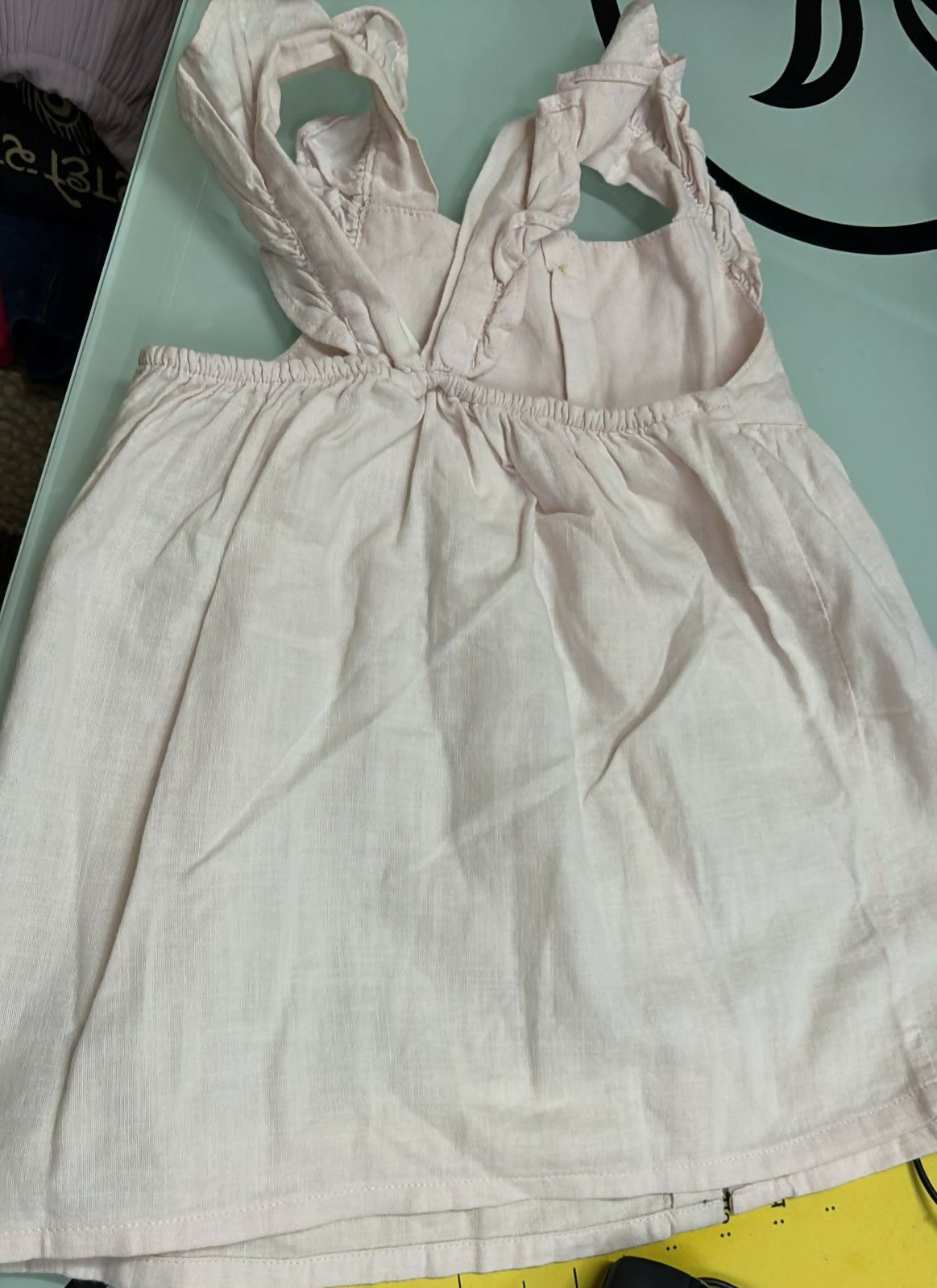 Light-colored dress with straps on a light green surface