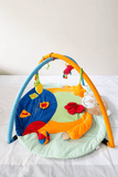 Mee Mee Baby Activity Play Gym Tummy Time Mat with hanging toys, soft cushioned mat, foldable design, and carry bag to encourage tummy time, sensory development, and motor skills.