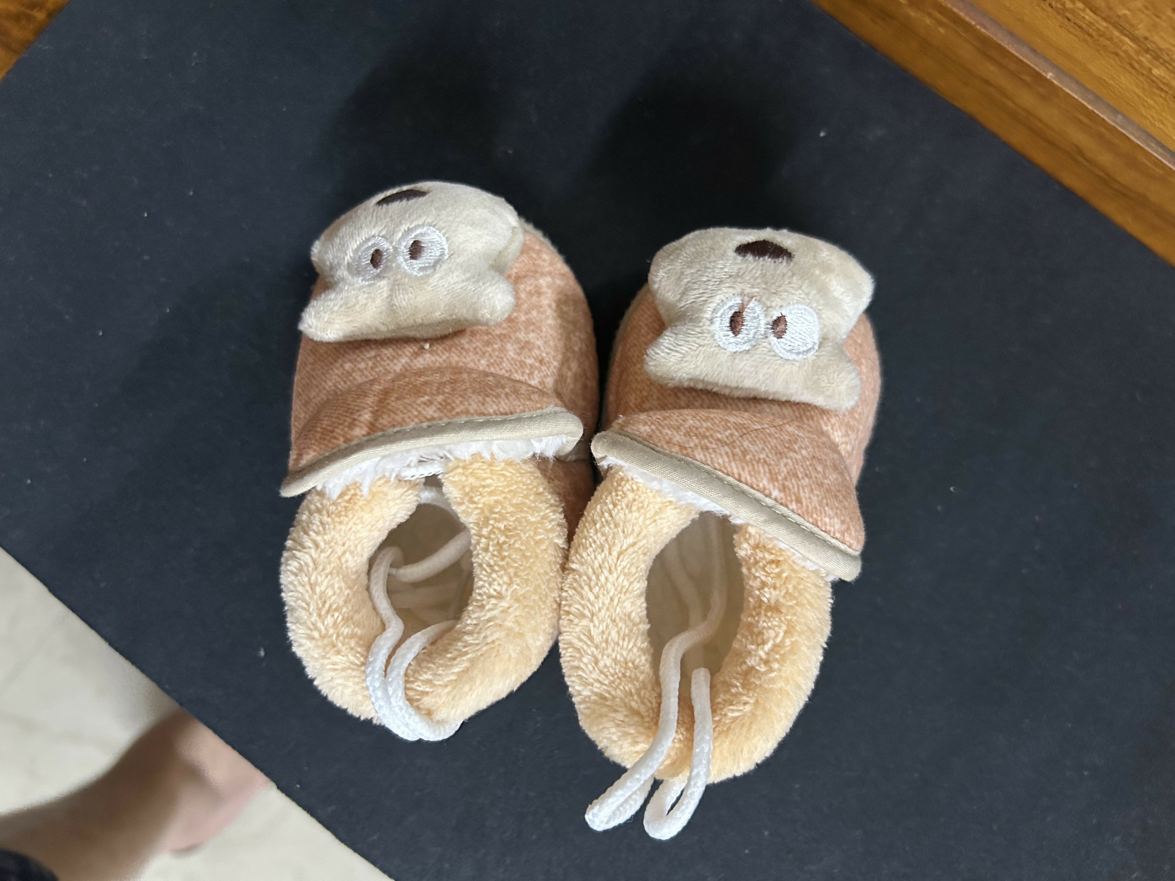 Pair of baby shoes with bear face design
