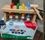 NESTA TOY wooden pounding bench with hammer featuring colorful pegs, smooth child-friendly wooden construction, and an interactive design to support hand-eye coordination, fine motor skills, and early learning.