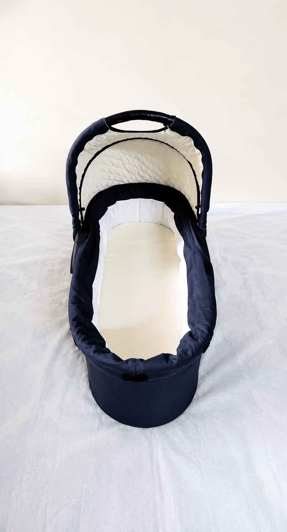 babycab Noah Carrycot Bassinet in Navy Blue, designed as a stroller attachment with a comfortable padded interior, protective canopy, sturdy construction, and cozy lie-flat space for newborns and young infants.