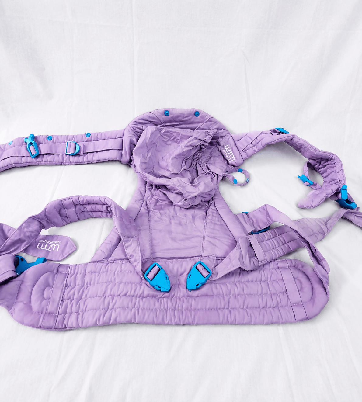 We Made Me Pao Papoose Three 3-in-1 Baby Carrier in Purple with multiple carrying positions, padded shoulder straps, adjustable waist belt, ergonomic support, and breathable fabric for comfortable babywearing.