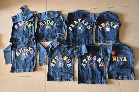 Set of denim vests with colorful letters on a wooden floor