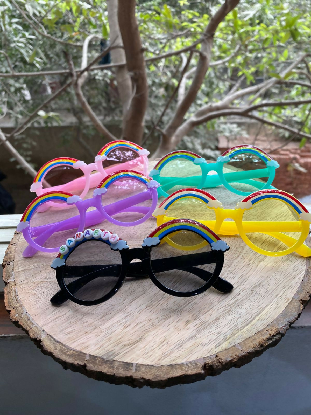 Colorful sunglasses with decorative elements on a wooden surface