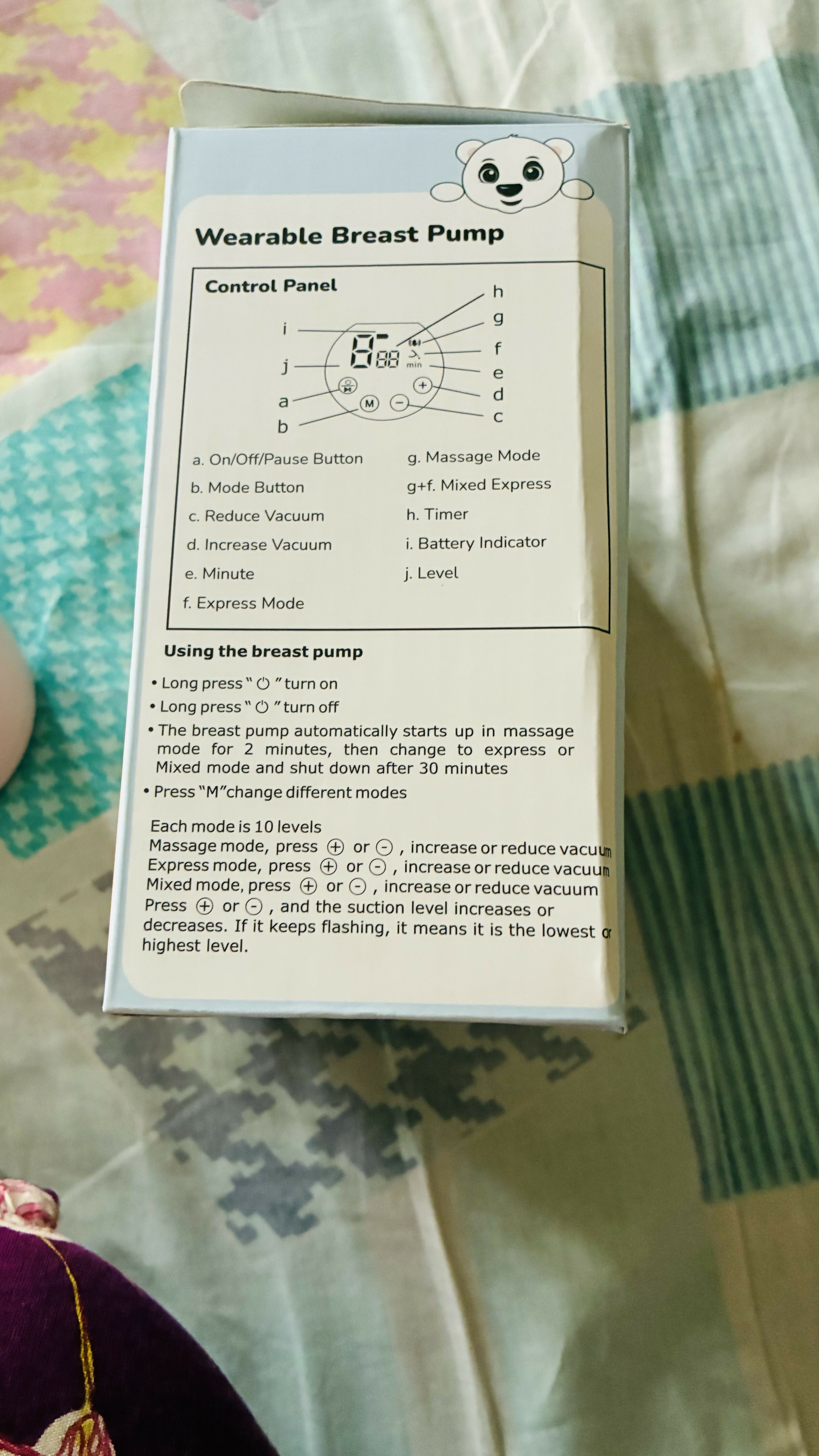 Wearable breast pump control panel with text on a patterned fabric background