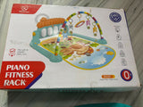 Baby Playgym with Piano Fitness Rack in Almost New condition featuring an activity mat, hanging toys and interactive piano setup to encourage kicking, reaching, hand-eye coordination and engaging supervised playtime.