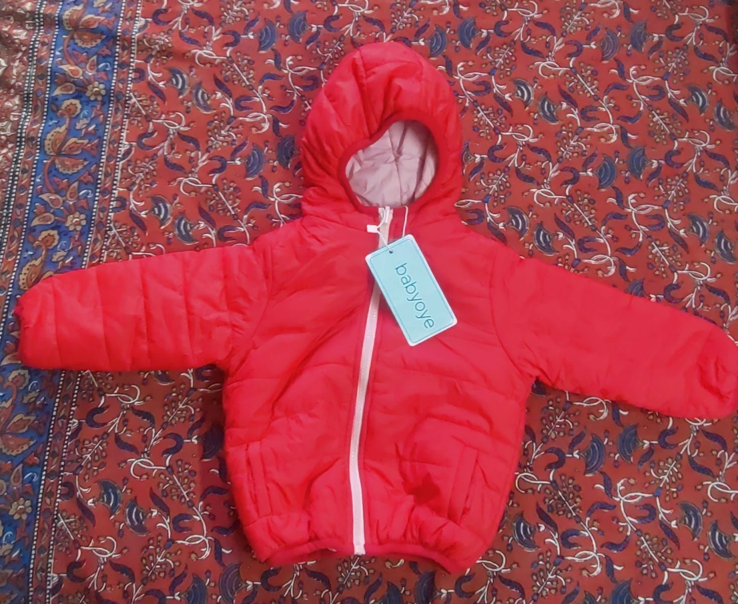 Vibrant red puffer jacket with hood for kids, featuring warm padded insulation, lightweight construction, front zip closure, and a cozy design for comfortable winter wear.