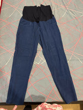 Blue pants with a black waistband on a patterned surface