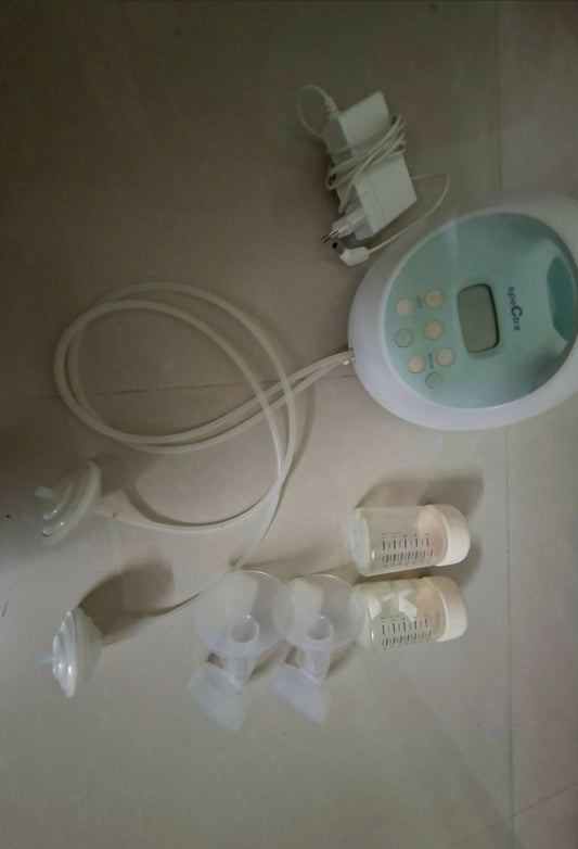 Breast pump set with bottles and accessories on a light surface