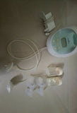Breast pump set with bottles and accessories on a light surface