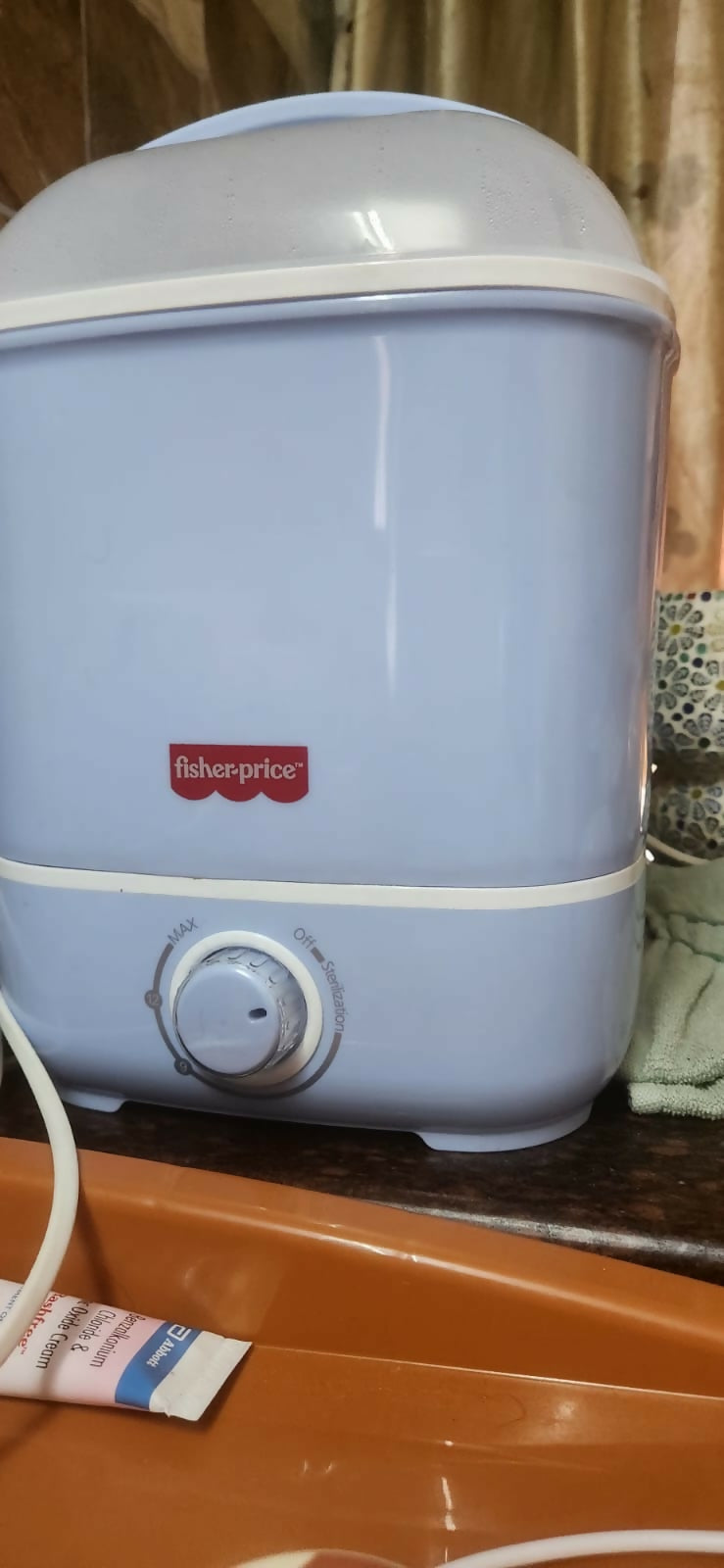 Blue and white baby bottle warmer on a wooden surface