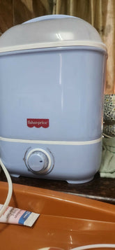 Blue and white baby bottle warmer on a wooden surface