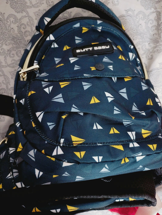 Navy blue backpack with yellow and white triangle pattern on a textured surface