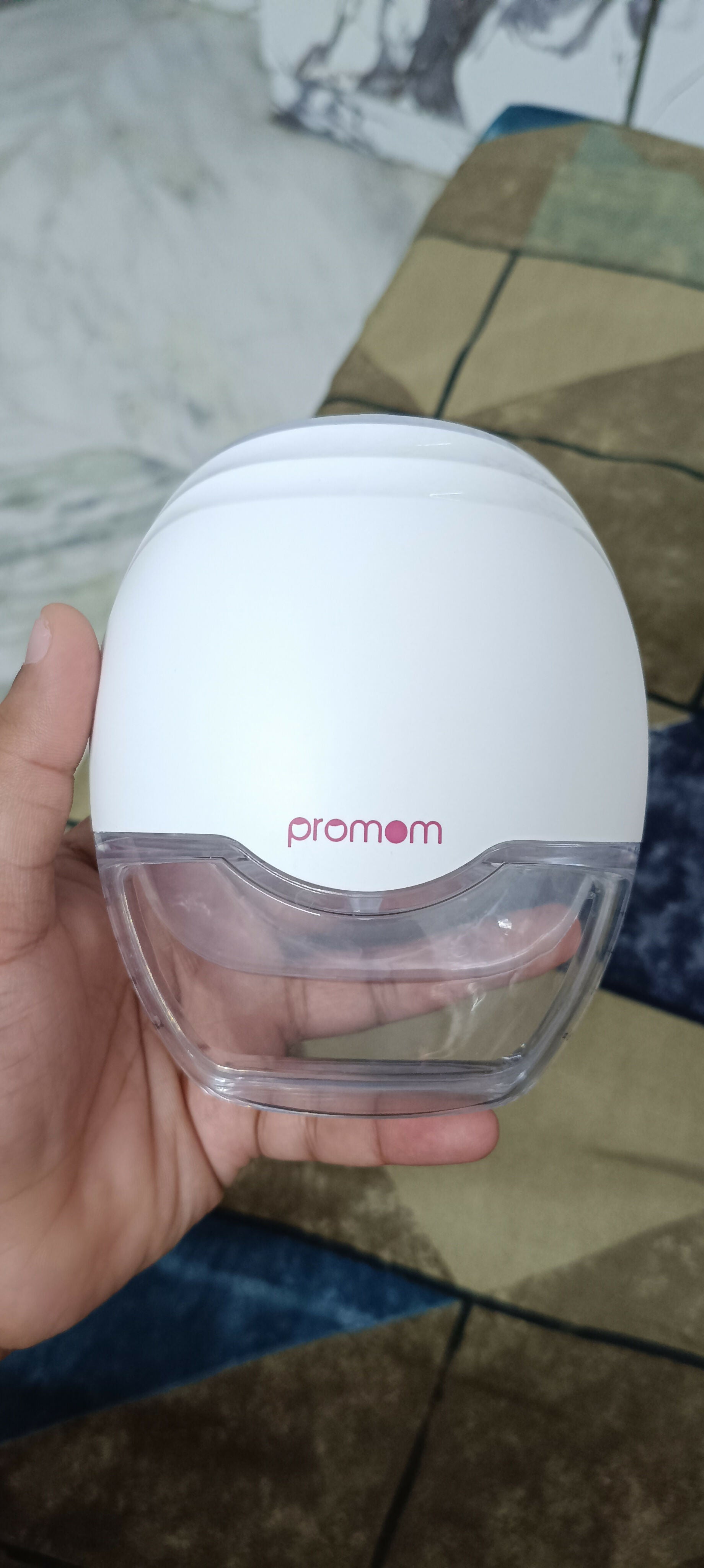 PROMOM electric wearable breast pump with hard case, hands-free design, compact milk collection cups, adjustable suction, and portable pumping support for breastfeeding mothers.