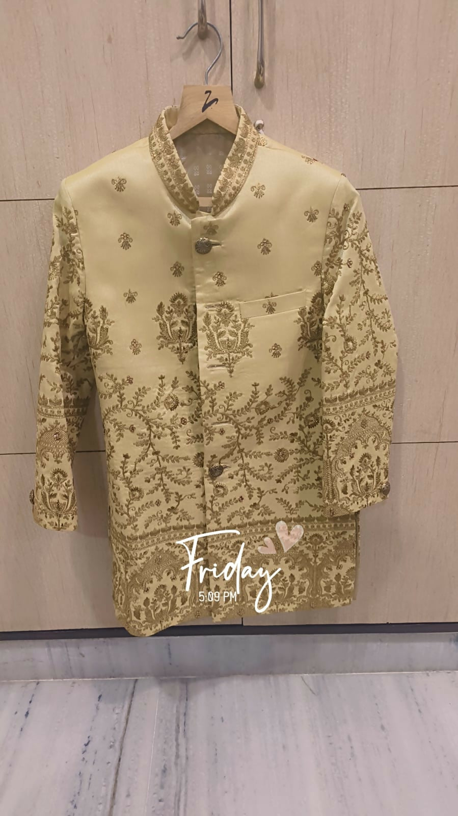 Light green embroidered blouse on a hanger with 'Friday' text on a wooden background