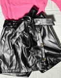 Black leather skirt with buttons and a pink top